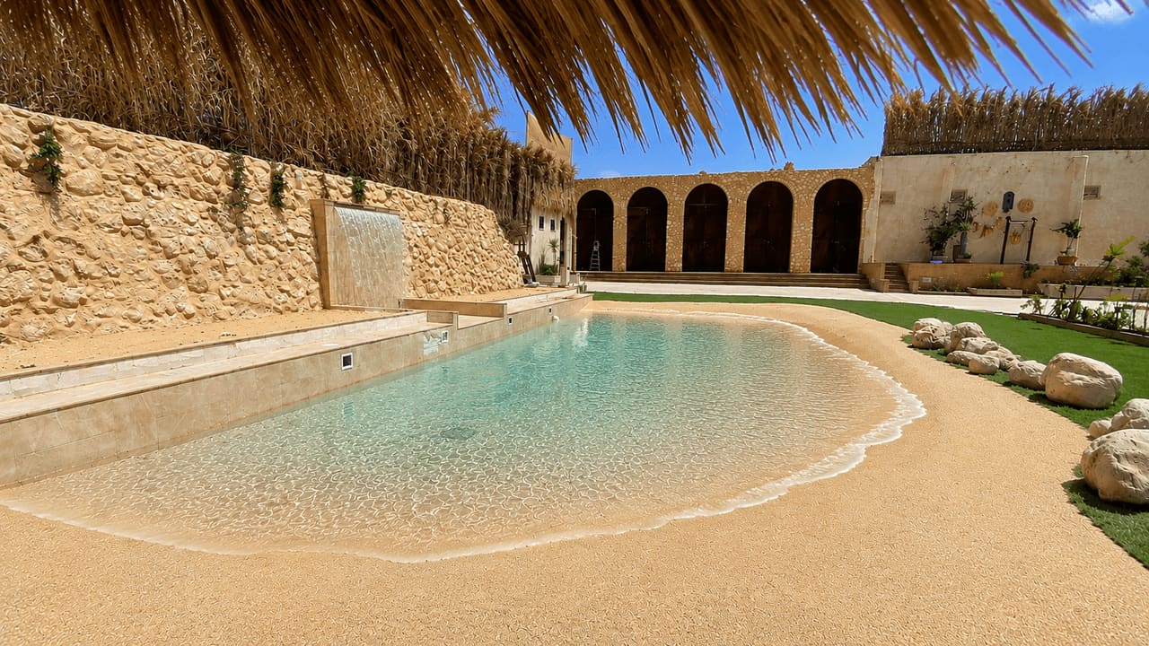 The sand lagoon pool beneath the stone arches